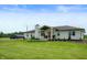 Scenic view of a ranch-style brick home with a covered porch, landscaping, and a dark outbuilding in the background at 10274 S 400 W, Pendleton, IN 46064