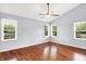 Bright bedroom featuring hardwood floors, vaulted ceilings, and three large windows at 10560 Lighthouse Way, Indianapolis, IN 46256