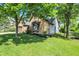 Charming brick home featuring manicured lawn and mature shade trees in a serene, suburban setting at 10560 Lighthouse Way, Indianapolis, IN 46256