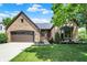 Inviting brick home with a two-car garage, manicured lawn, and established landscaping at 10560 Lighthouse Way, Indianapolis, IN 46256