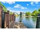 Scenic pond view from wooden dock, featuring community homes and landscaping under a blue sky at 10560 Lighthouse Way, Indianapolis, IN 46256