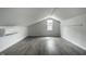 Finished attic area with gray floors, neutral walls, and a window is bright and airy at 10833 Marquette Rd, Zionsville, IN 46077