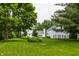 Scenic backyard view featuring a lush lawn and a charming home surrounded by mature trees at 10833 Marquette Rd, Zionsville, IN 46077