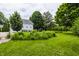 Lush backyard showcasing vibrant green grass and mature trees surrounding a charming home at 10833 Marquette Rd, Zionsville, IN 46077