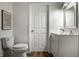 Bathroom with toilet, vanity and sink. Features white cabinets and laminate flooring at 10833 Marquette Rd, Zionsville, IN 46077