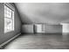 Spacious bonus room features stylish gray built-ins, wood flooring, and ample natural light from the window at 10833 Marquette Rd, Zionsville, IN 46077