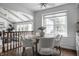 Dining area with round table, upholstered chairs, large window, and hardwood floors next to living space at 10833 Marquette Rd, Zionsville, IN 46077
