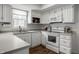 Bright kitchen features white cabinetry, stainless steel appliances, and hardwood floors at 10833 Marquette Rd, Zionsville, IN 46077