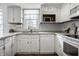 Well-lit kitchen showcases white cabinets, stainless steel appliances, and hardwood floors at 10833 Marquette Rd, Zionsville, IN 46077