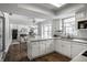 Open kitchen with white cabinetry, skylight, and hardwood floors flowing into an adjacent living area at 10833 Marquette Rd, Zionsville, IN 46077