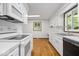 Kitchen features white appliances, cabinets, and hardwood floors at 11123 Haverstick Rd, Carmel, IN 46033