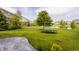 Large backyard with lush green lawn, a trampoline, and view of nearby homes and lake at 11552 Buckskin Dr, Zionsville, IN 46077