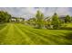 Scenic view of a lush backyard with a tranquil pond surrounded by well-manicured lawn and neighborhood homes at 11552 Buckskin Dr, Zionsville, IN 46077