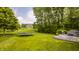 Sprawling backyard with a trampoline, hot tub, patio, and mature trees in a neighborhood setting at 11552 Buckskin Dr, Zionsville, IN 46077