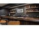 The basement bar provides a sophisticated space with open shelving and counter space for mixing cocktails at 11552 Buckskin Dr, Zionsville, IN 46077