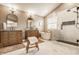 Bright bathroom with double vanities, soaking tub, and glass enclosed shower with marble tile and a bench at 11552 Buckskin Dr, Zionsville, IN 46077