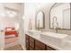 Bright bathroom with double sinks, white vessel sinks, wooden cabinets, mirrors, and modern fixtures at 11552 Buckskin Dr, Zionsville, IN 46077