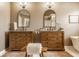 Bright primary bathroom with double vanities, marble floors, bronze lighting fixtures, and a standalone tub at 11552 Buckskin Dr, Zionsville, IN 46077
