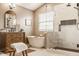 Bright bathroom with soaking tub near a window, and a glass enclosed shower featuring marble tile and black hardware at 11552 Buckskin Dr, Zionsville, IN 46077
