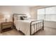 Bedroom with a metal frame bed, side table, lamps, and natural light from the window at 11552 Buckskin Dr, Zionsville, IN 46077