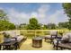 Outdoor deck with seating, side tables, a fire pit and a view overlooking the backyard and lake at 11552 Buckskin Dr, Zionsville, IN 46077