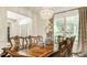Formal dining room with a wood table, decorative chandelier, and large windows with natural light at 11552 Buckskin Dr, Zionsville, IN 46077