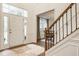 Bright foyer featuring a beautiful front door, wood floors, staircase, and view into dining space at 11552 Buckskin Dr, Zionsville, IN 46077