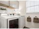 Laundry room with modern gray cabinets, white washer and dryer, and a window with natural light at 11552 Buckskin Dr, Zionsville, IN 46077