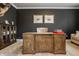 Home office featuring a large wooden desk, dark accent walls, and neutral carpet at 11552 Buckskin Dr, Zionsville, IN 46077