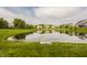 Scenic pond surrounded by green grass, reflecting the sky and the nearby houses in the neighborhood at 11552 Buckskin Dr, Zionsville, IN 46077