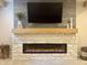 Modern electric fireplace with stone surround and wood mantle adds warmth to the living space at , Noblesville, IN 46060