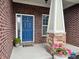 Close-up of the front entrance with a blue door, stone pillars, and fresh flowers at , Noblesville, IN 46060