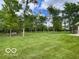 Spacious, lush backyard with mature trees and a charming bench near a wooded area at 11898 N 200 W, Fountaintown, IN 46130
