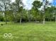 Lush green backyard with mature trees and a charming bench, creating a peaceful outdoor retreat at 11898 N 200 W, Fountaintown, IN 46130