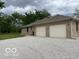 Exterior view of brick home and large 2-door garage with a gravel driveway at 11898 N 200 W, Fountaintown, IN 46130