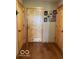 Hallway with hardwood floors and wooden doors, showcasing decorative wall hangings at 11898 N 200 W, Fountaintown, IN 46130