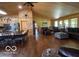 Open concept living area with hardwood floors, wood-paneled ceiling, leather furniture, and eat-in kitchen at 11898 N 200 W, Fountaintown, IN 46130