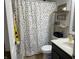 Well-lit bathroom with a polka dot shower curtain, and storage shelving that adds a personal touch at 1420 Wigwam Ln, Martinsville, IN 46151