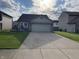 Single Gathering home featuring a two-car garage, tidy lawn and patriotic decorations at 1420 Wigwam Ln, Martinsville, IN 46151