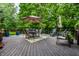 Backyard deck with outdoor furniture, a dining table under an umbrella, and lush green surroundings, ideal for entertaining at 14274 Matt St, Carmel, IN 46033