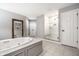 Bright bathroom with a jetted tub, a glass enclosed shower and neutral tile flooring at 14274 Matt St, Carmel, IN 46033