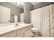 Bathroom with a white vanity, large mirror, and shower with a white curtain, creating a clean and functional space at 14274 Matt St, Carmel, IN 46033