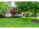 Landscaped front yard with mature trees and shrubs surrounding a classic brick home at 14274 Matt St, Carmel, IN 46033
