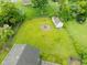Aerial view showcases a spacious backyard with a fire pit, storage shed, and mature trees, great for outdoor living at 1440 Fenwick Ave, Indianapolis, IN 46219