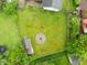 Aerial view of the property features a spacious backyard with a circular fire pit, storage shed and lush greenery at 1440 Fenwick Ave, Indianapolis, IN 46219