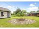 Backyard with a brick fire pit surrounded by stone, offering a cozy outdoor gathering space at 1440 Fenwick Ave, Indianapolis, IN 46219