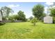 Expansive backyard with lush green grass, mature trees, and storage shed at 1440 Fenwick Ave, Indianapolis, IN 46219