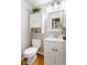 Well-lit half-bathroom with white vanity, and classic fixtures at 1440 Fenwick Ave, Indianapolis, IN 46219