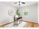 A sunny bedroom features hardwood floors, a ceiling fan, a window, and a stylish desk with a comfortable chair at 1440 Fenwick Ave, Indianapolis, IN 46219