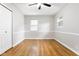 Bedroom with hardwood floors, neutral walls, a ceiling fan, and plenty of natural light from two windows at 1440 Fenwick Ave, Indianapolis, IN 46219